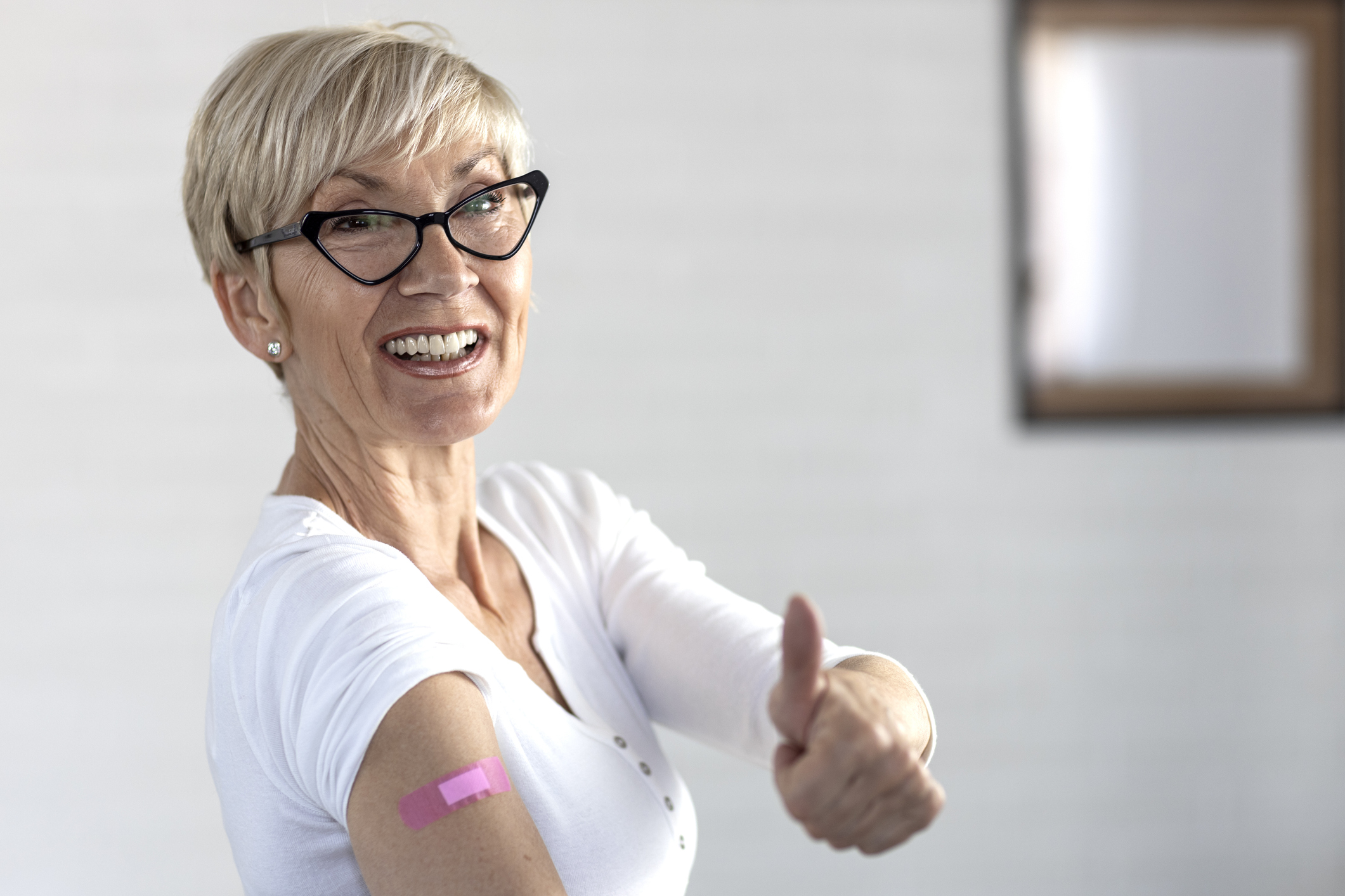 A woman giving a thumbs-up after getting a shot.